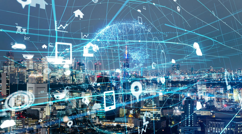 Night skyline overlaid with glowing data links and floating icons for phones, homes, cameras and cloud storage.