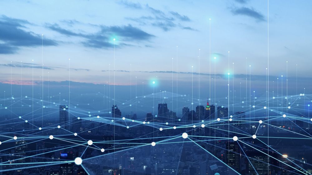 City skyline at dusk overlaid with a web of glowing nodes and lines linking points across it.