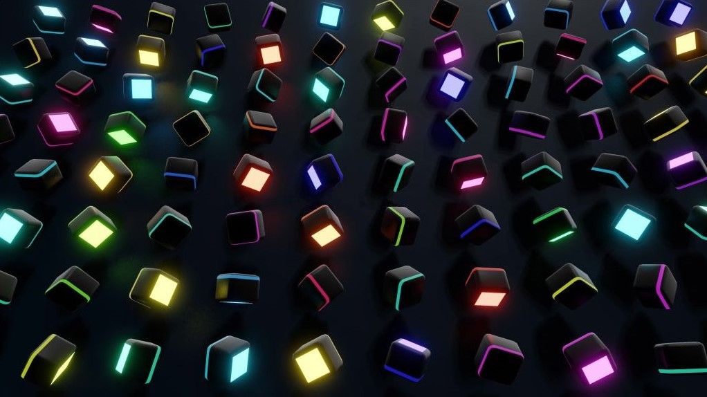 Rows of black cubes scattered across a dark surface, each with a single face glowing in a different neon colour.