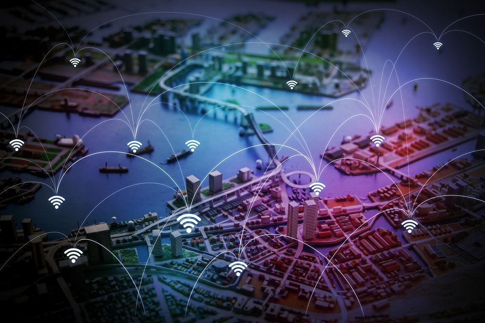 Scale model of a harbour city overlaid with Wi-Fi icons and arcs linking districts across the water.